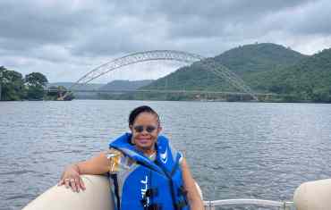 Tourist enjoying a boat cruise on the Volta River, highlighting leisure activities and travel costs in Ghana.