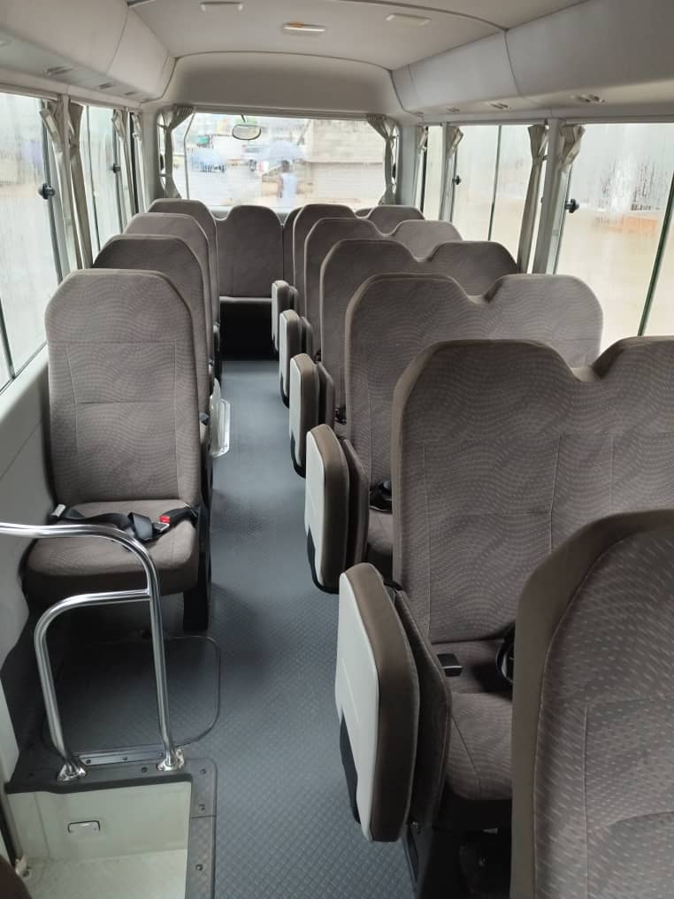 Interior of Toyota Coaster bus with comfortable seating for group tours in Ghana by Timeh Tours