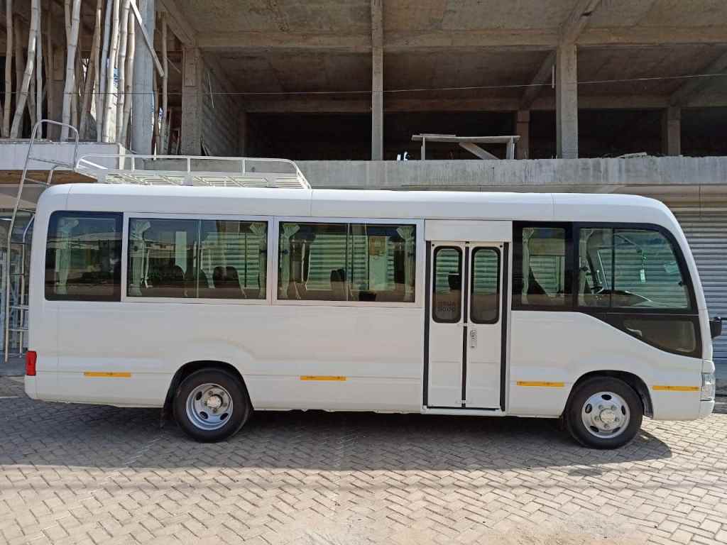 Side view of Toyota Coaster bus for group tours and transportation in Ghana with Timeh Tours