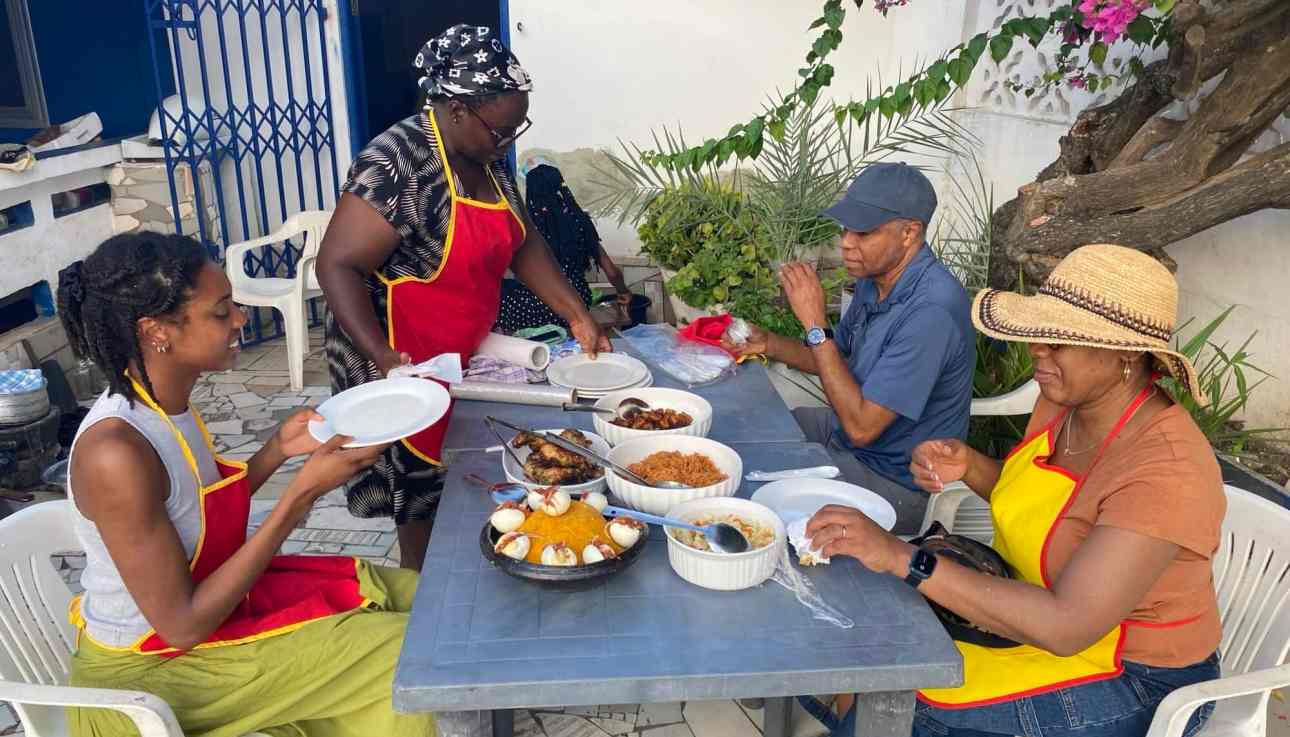 Tourists enjoying Ghanaian cuisine and delicious traditional dishes at a local Ghanaian house.