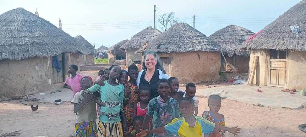Tourist interacting with local children in a village in Northern Ghana during a cultural experience with Timeh Tours