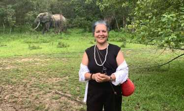 Tourist at Mole National Park, Ghana, with an African elephant visible in the background during a guided wildlife safari with Timeh Tours