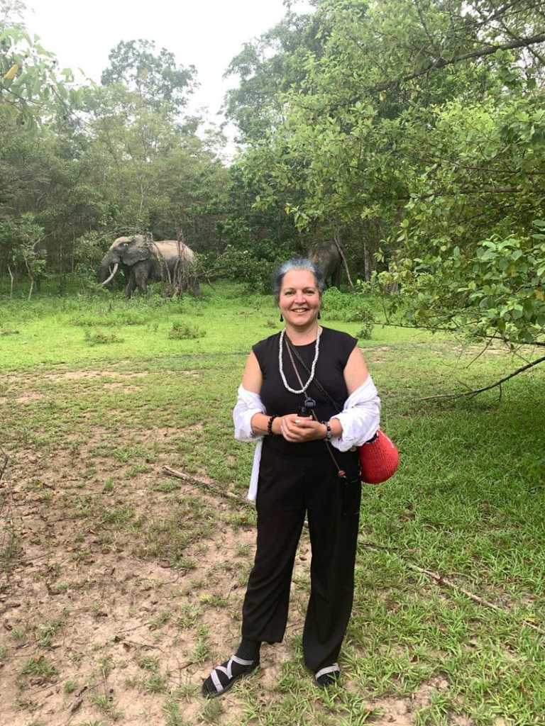 Tourist at Mole National Park, Ghana, with an African elephant visible in the background during a guided wildlife safari with Timeh Tours